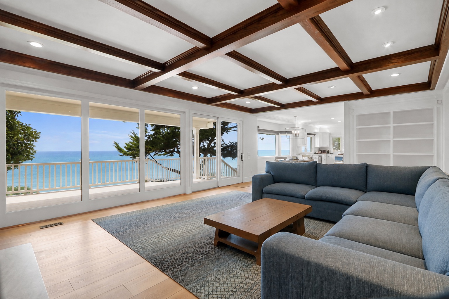 Same living room furnished with a sectional, rug and coffee table